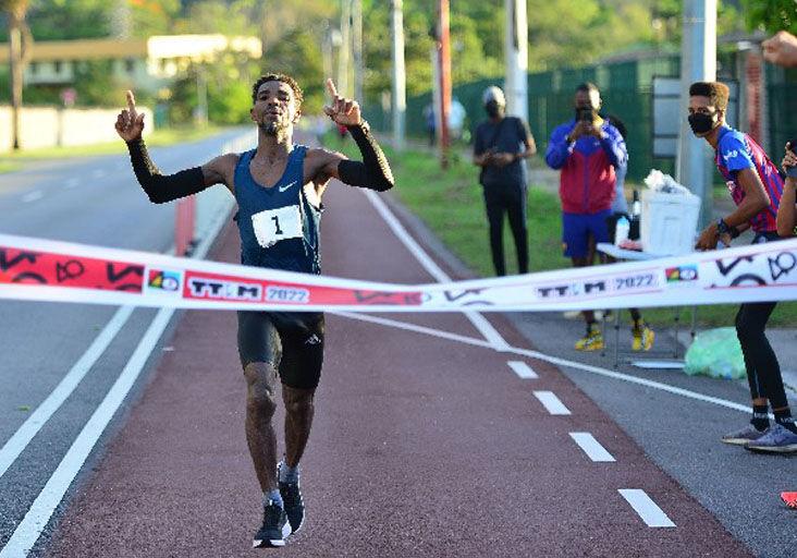 CHAMPION: Kelvin Johnson crosses the finish line on the bicycle path in Chaguaramas, yesterday, to win the Trinidad and Tobago International Marathon (TTIM) 40th Edition title. The Guyanese-born runner returned a time of two hours, 55 minutes and 33 seconds.  —Photo: ISHMAEL SALANDY CHAMPION: Kelvin Johnson crosses the finish line on the bicycle path in Chaguaramas, yesterday, to win the Trinidad and Tobago International Marathon (TTIM) 40th Edition title. The Guyanese-born runner returned a time of two hours, 55 minutes and 33 seconds.  —Photo: ISHMAEL SALANDY