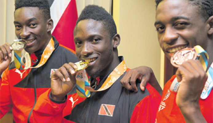 Commonwealth youth 100m sprint prince Adell Colthrust,centre, flanked by fellow countrymen Tyriq Horsford,right, and swimmer Jerron Thompson, following their arrival at the Piarco International Airport on Tuesday night. PHOTO: CA-IMAGES/ALLAN CRANE Commonwealth youth 100m sprint prince Adell Colthrust,centre, flanked by fellow countrymen Tyriq Horsford,right, and swimmer Jerron Thompson, following their arrival at the Piarco International Airport on Tuesday night. PHOTO: CA-IMAGES/ALLAN CRANE