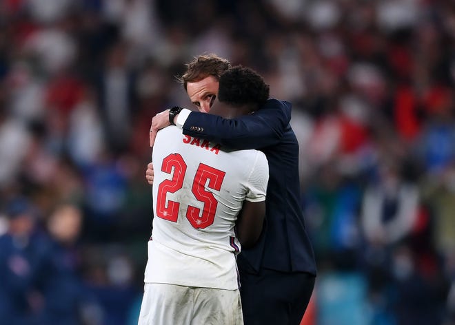 England's Bukayo Saka was consoled by his head coach, Gareth Southgate, after his penalty miss Sunday in the Euro 2020 Championship Final. England's Bukayo Saka was consoled by his head coach, Gareth Southgate, after his penalty miss Sunday in the Euro 2020 Championship Final.