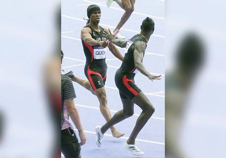 ONE SHORT: Renny Quow, left, hands the baton to his Trinidad and Tobago teammate Jereem “The Dream” Richards in the first of two Olympic Games men’s 4x400 metres qualifying round heats at the Stade de France, in Paris, yesterday. Quow, running the lead-off leg for T&T, lost his right shoe during the race. —Photo: BRENT STUBBS (Image obtained at trinidadexpress.com) ONE SHORT: Renny Quow, left, hands the baton to his Trinidad and Tobago teammate Jereem “The Dream” Richards in the first of two Olympic Games men’s 4x400 metres qualifying round heats at the Stade de France, in Paris, yesterday. Quow, running the lead-off leg for T&T, lost his right shoe during the race. —Photo: BRENT STUBBS (Image obtained at trinidadexpress.com)