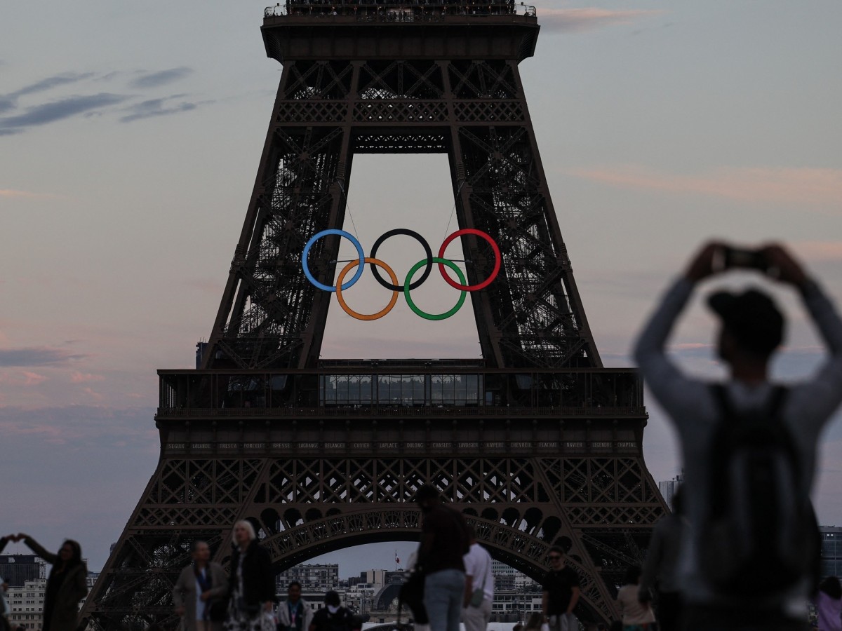 Pedestrians take pictures of the Olympic rings on the Eiffel Tower. GETTY IMAGES (Image obtained at insidethegames.biz) Pedestrians take pictures of the Olympic rings on the Eiffel Tower. GETTY IMAGES (Image obtained at insidethegames.biz)
