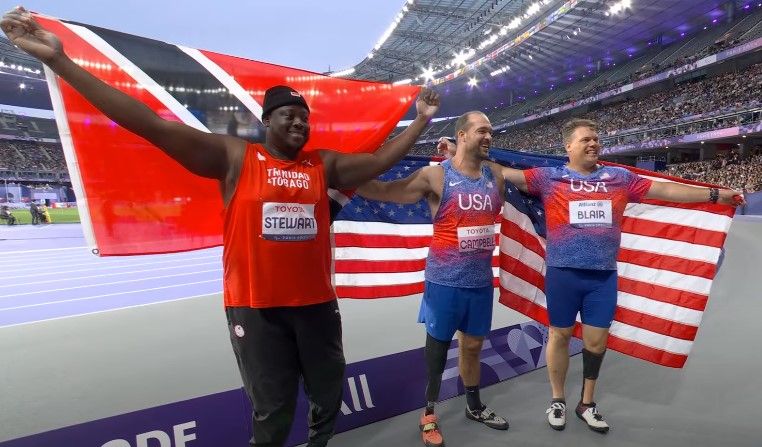 T&T Paralympian Akeem Stewart, left, celebrates after winning a silver medal in the Men’s F64 Discuss event at the 2024 Paris Paralympic Games in France, yesterday. The event’s winner was Jeremy Campbell of the USA, centre, while fellow American David Blair placed third. (Image obtained at guardian.co.tt) T&T Paralympian Akeem Stewart, left, celebrates after winning a silver medal in the Men’s F64 Discuss event at the 2024 Paris Paralympic Games in France, yesterday. The event’s winner was Jeremy Campbell of the USA, centre, while fellow American David Blair placed third. (Image obtained at guardian.co.tt)