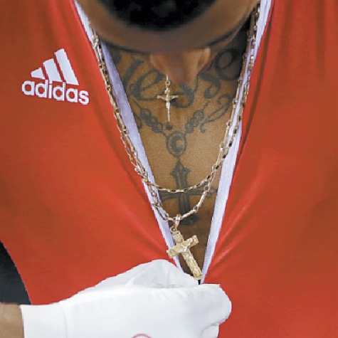 T&T's Nijsane Nicholas Phillip unzips his jersey during a track cycling men’s sprint event, at the 2012 Summer Olympics, yesterday, in London. AP Photo