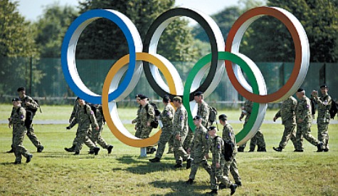 Members of the British Armed Reserves Unit walk past the Olympic rings on the grounds of the rowing venue at the 212 Summer Olympics.